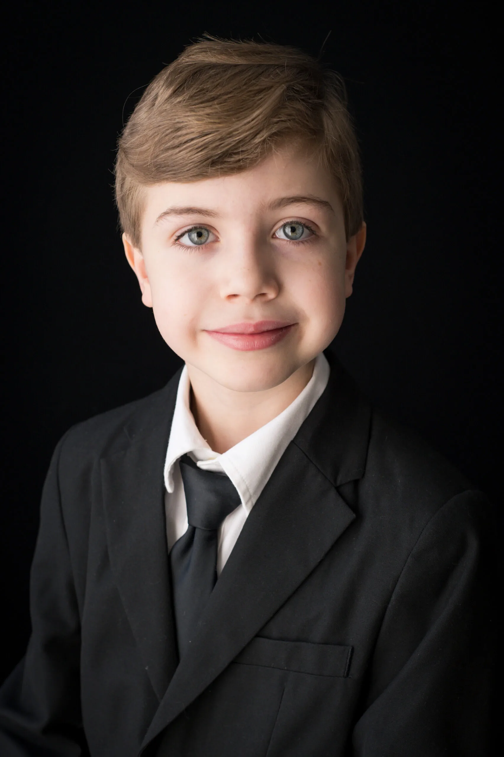 photograph of smiling boy with blue eyes looking at the camera