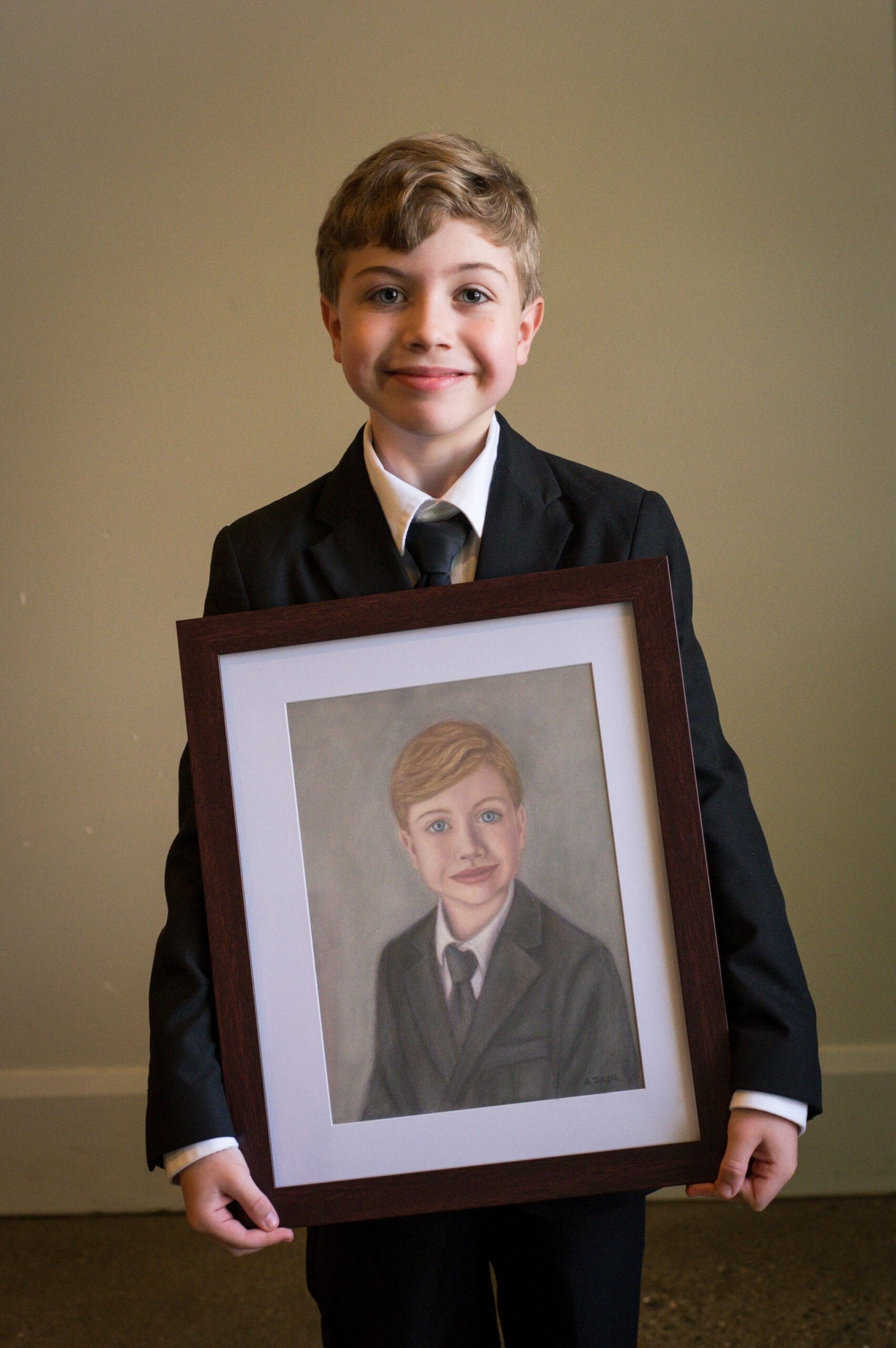 Color photo of boy with pastel portrait of himself